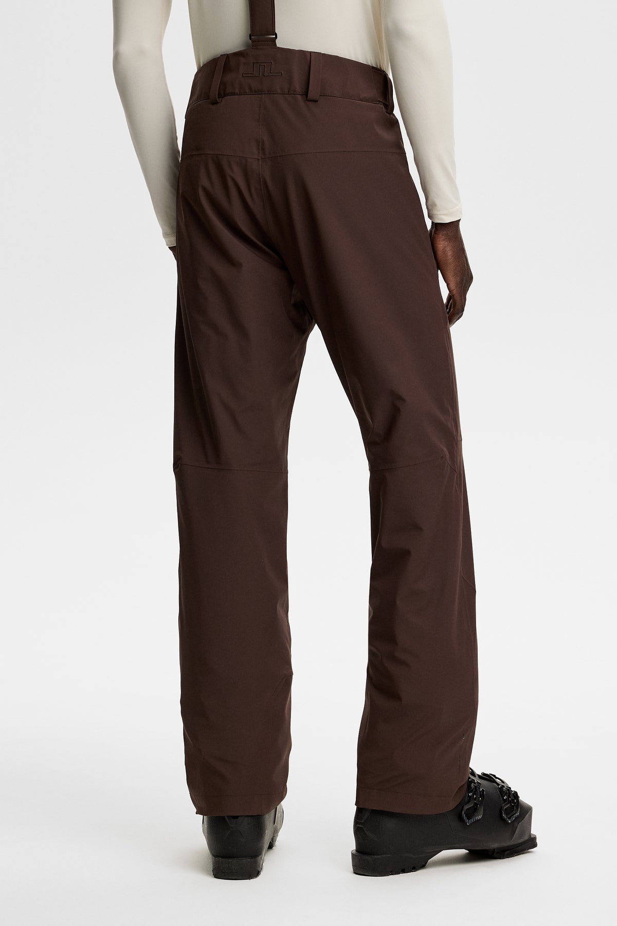 Set bagfra: Crue Suspender Pant i Seal Brown med seler, bæltestropper og Bridge-logo bagpå.