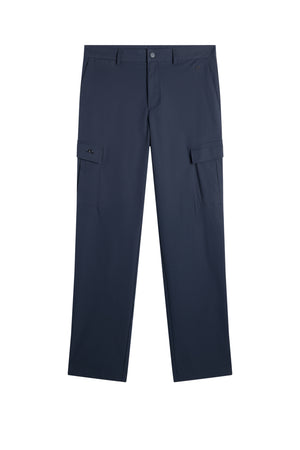 Framifrån: Logan Cargo pant i JL Navy med cargofickor på sidorna, bälteshällor och diskret Bridge-logotyp.