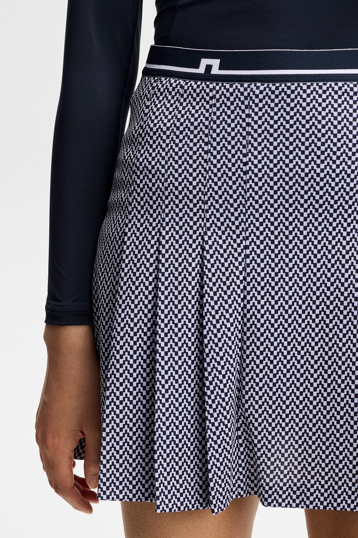 Gros plan : Harlow Print Skirt bleu marine à motif graphique, plis et logo Bridge sur la ceinture.