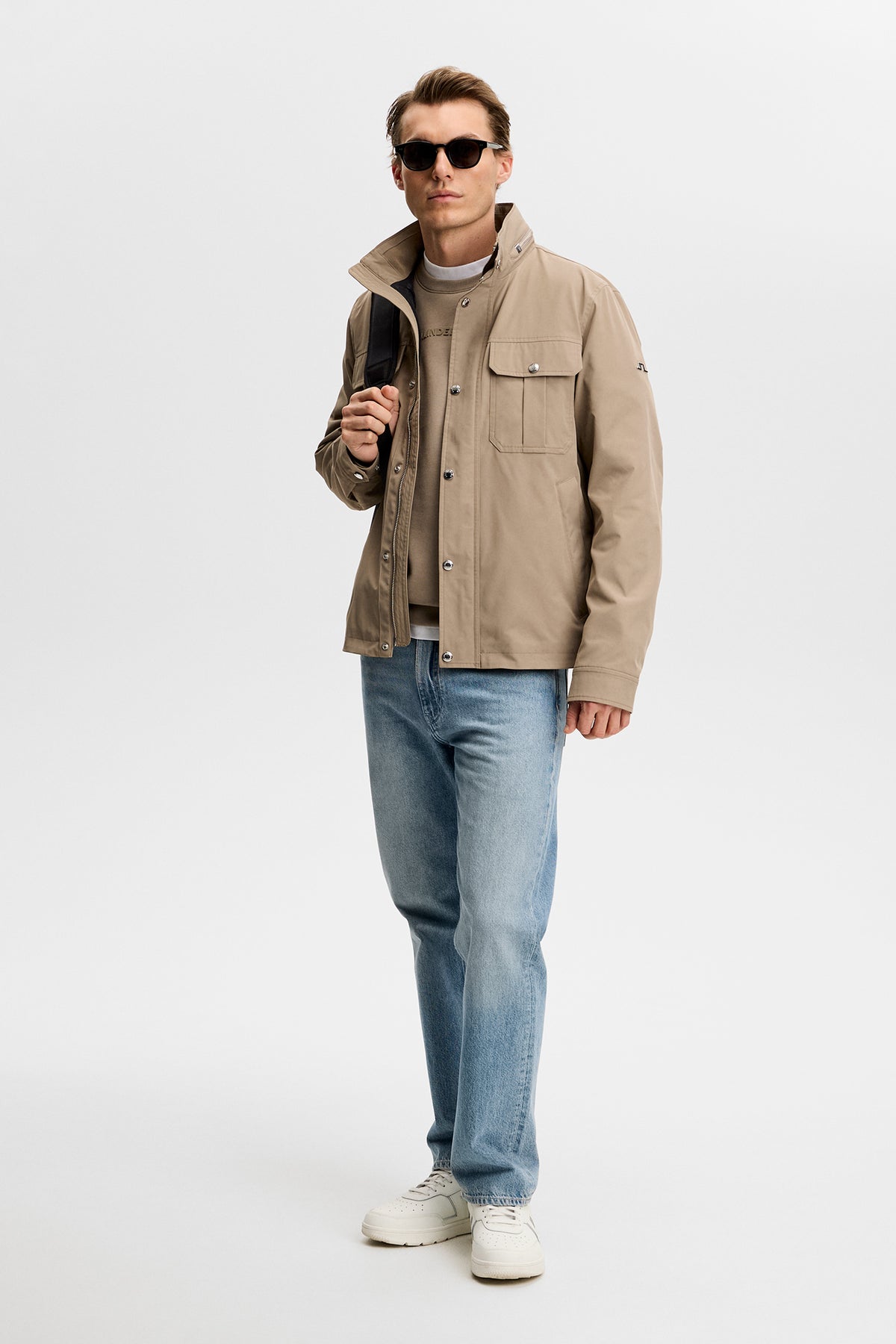 Model wearing the Bailey Recy Poly Jacket in Brindle with jeans in a studio setting.