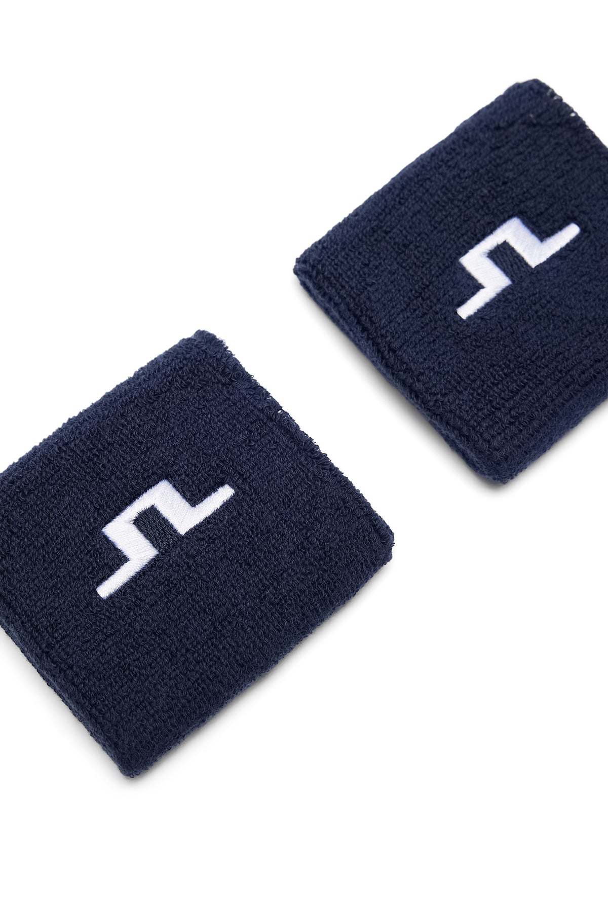 Bovenaanzicht: Twee Juno Wristbands in JL Navy van badstof met geborduurd wit Bridge-logo.