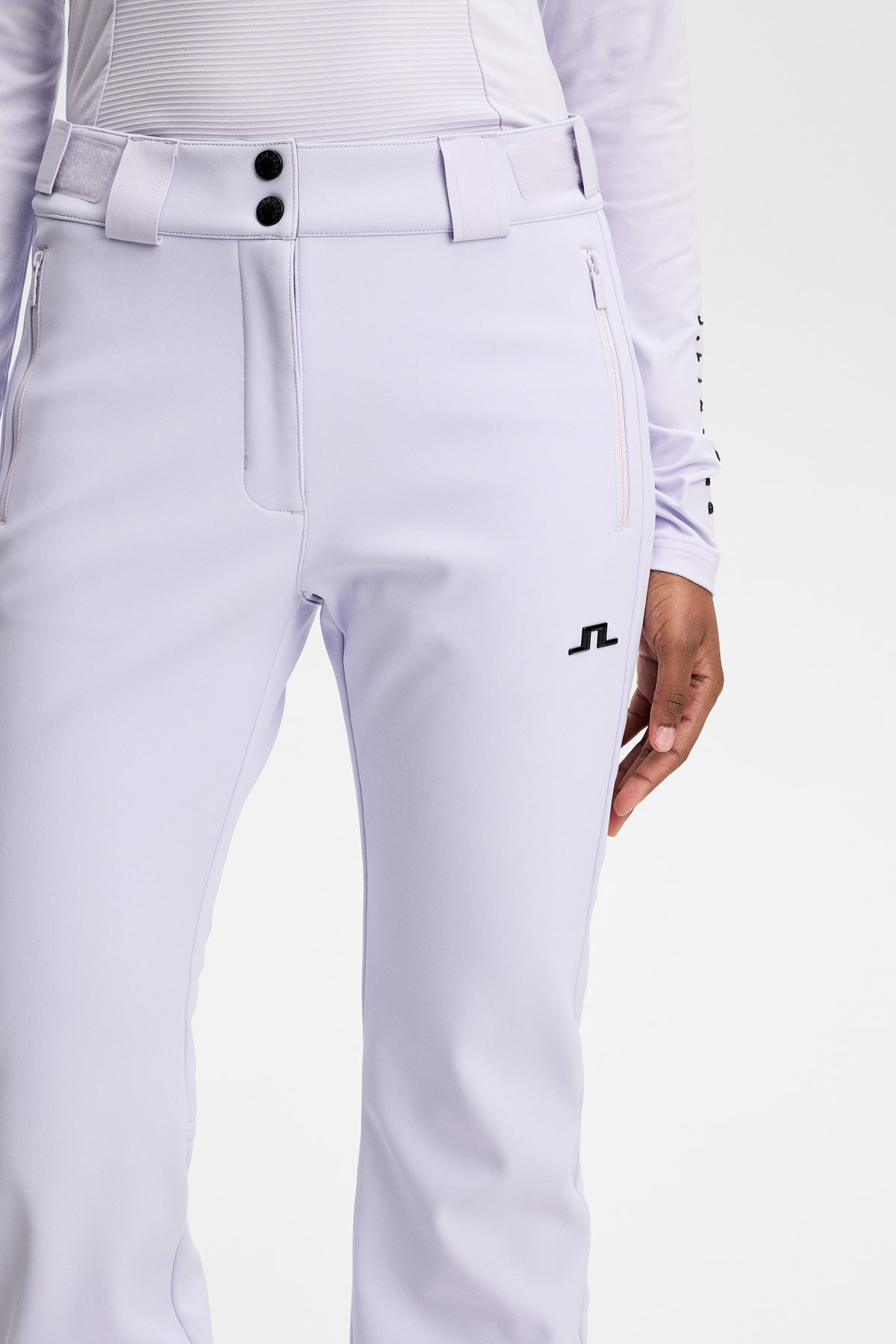 Nærbillede: Stanford Softshell Ski Pant i Purple Heather med lynlåslommer, bæltestropper og sort Bridge-logo.