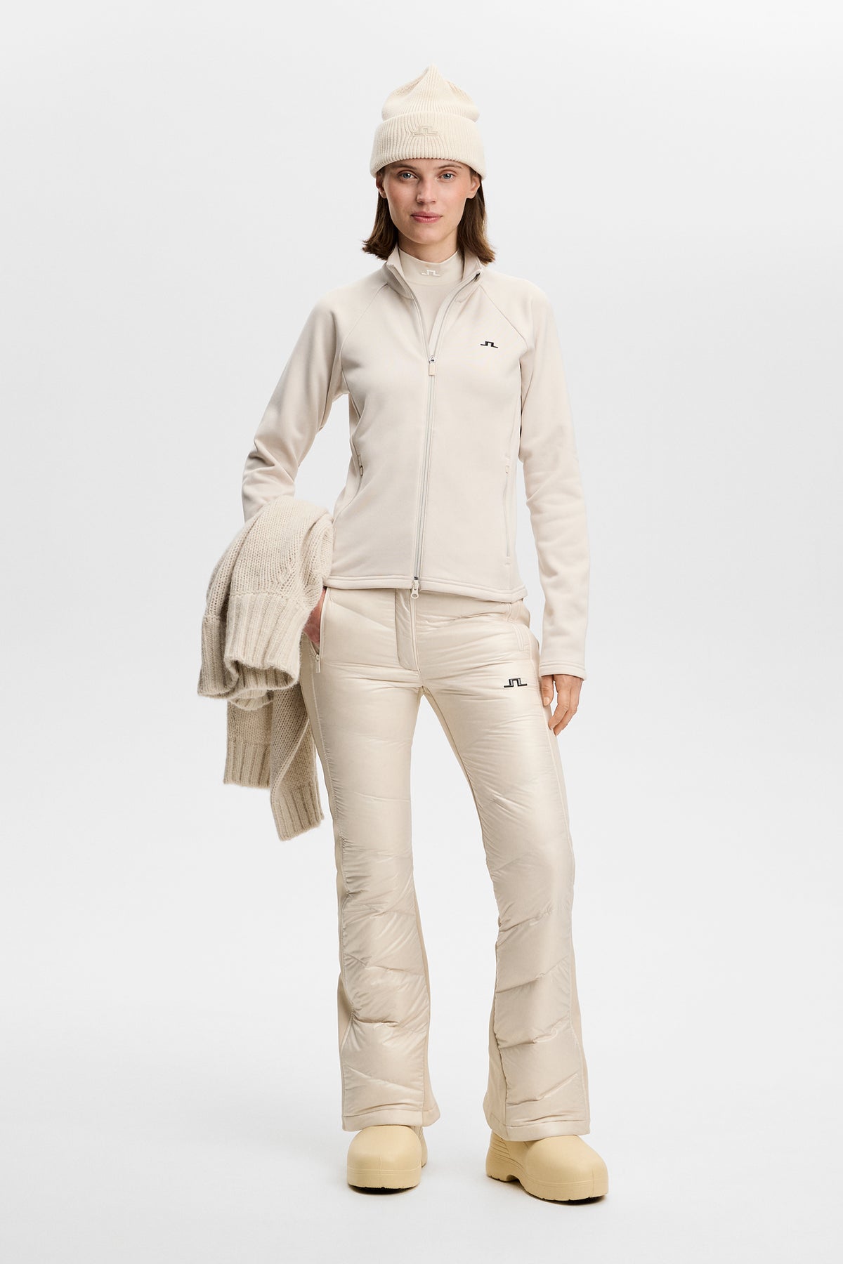 Model wearing the Portia Polartec Mid Layer in Moonbeam with a high neck and front zipper.