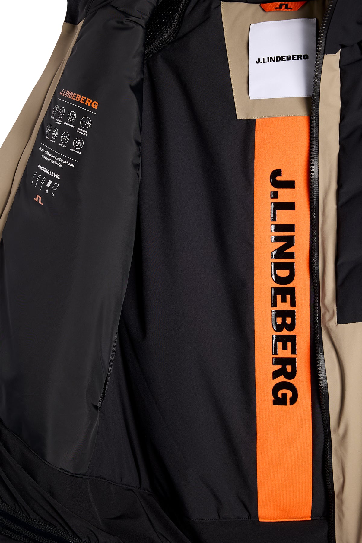 Nærbillede: Indersiden af Blackwell Jacket i Brindle med sort for, orange logopanel og J.LINDEBERG-branding.