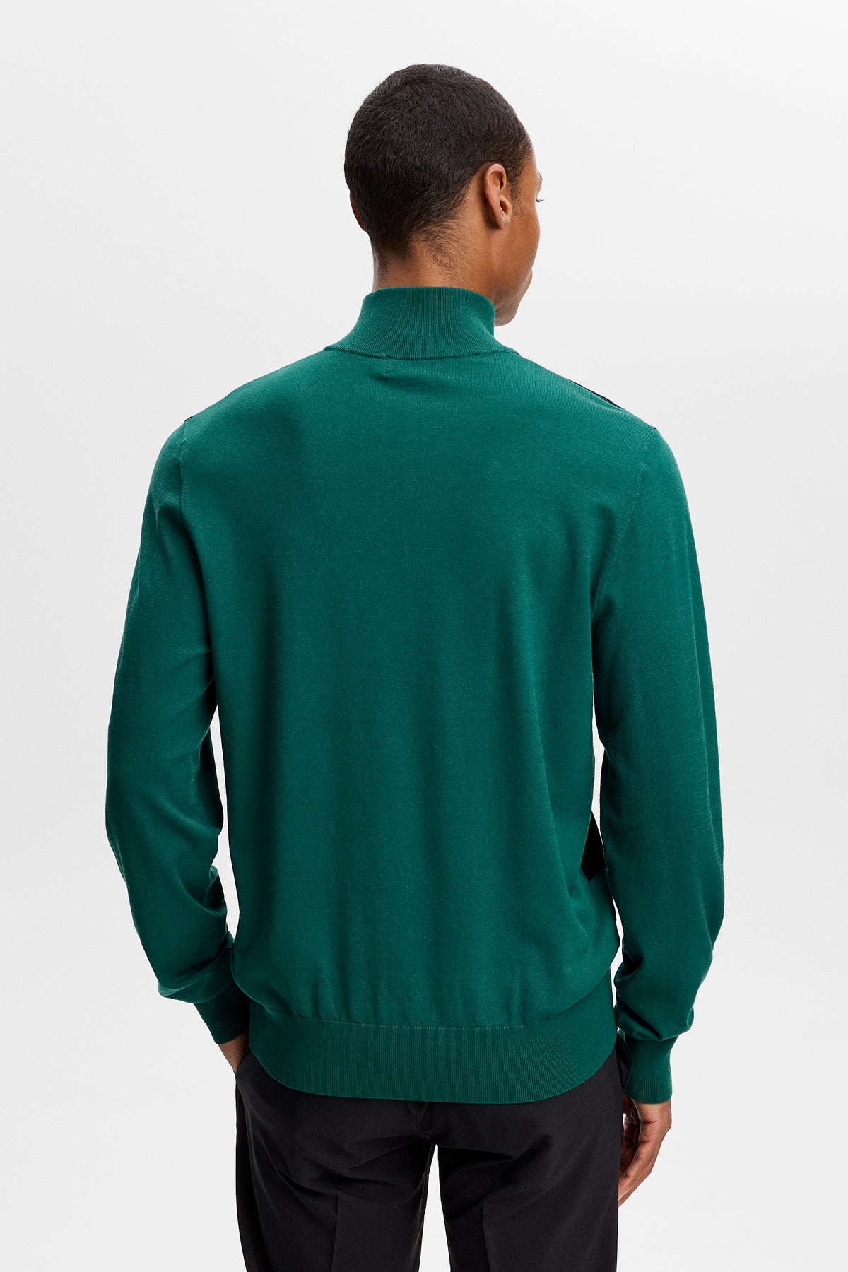 Set bagfra: Grøn Kendrick Knitted Zip Sweater på model med ribbede manchetter og kant.