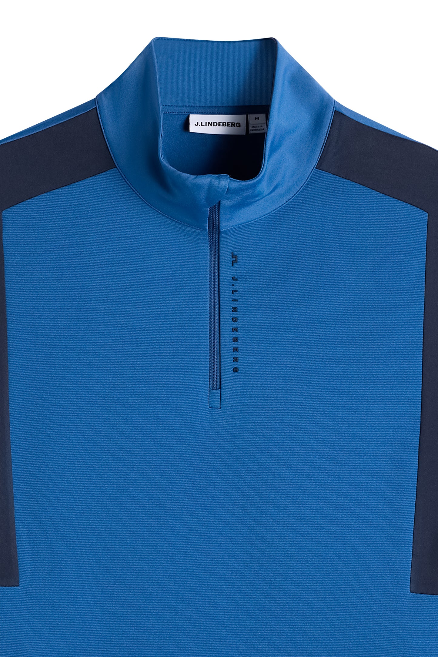 Close-up: Finn Quarter Zip Mid Layer in Set Sail met opstaande kraag, korte rits en verticaal J.Lindeberg-logo.