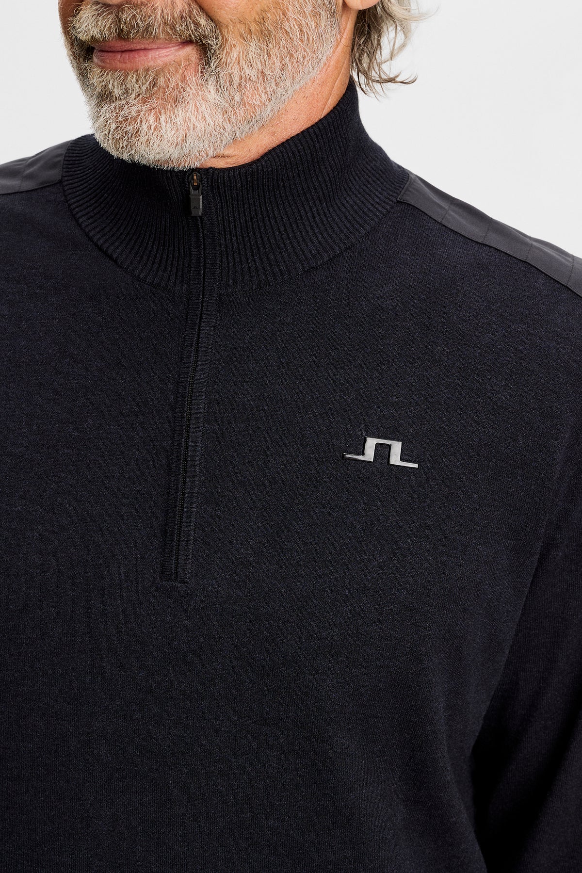 Nærbillede: Sort Jeffrey Windbreaker Sweater med halv lynlås, ribstrikket krave og Bridge-logo på brystet.