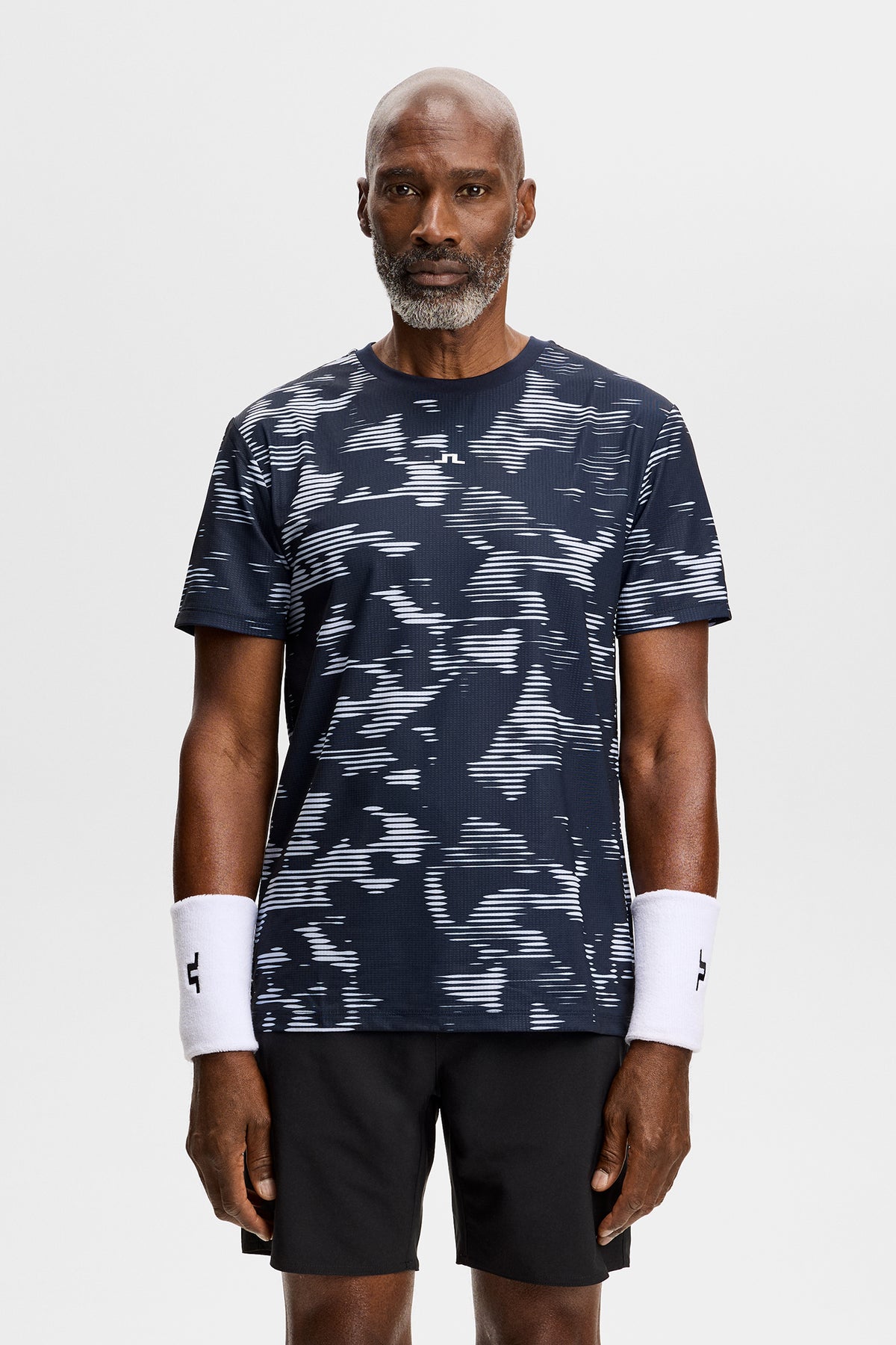 Vooraanzicht: Model draagt het Josip Printed T-shirt met all-over print en Bridge-logo op de borst.