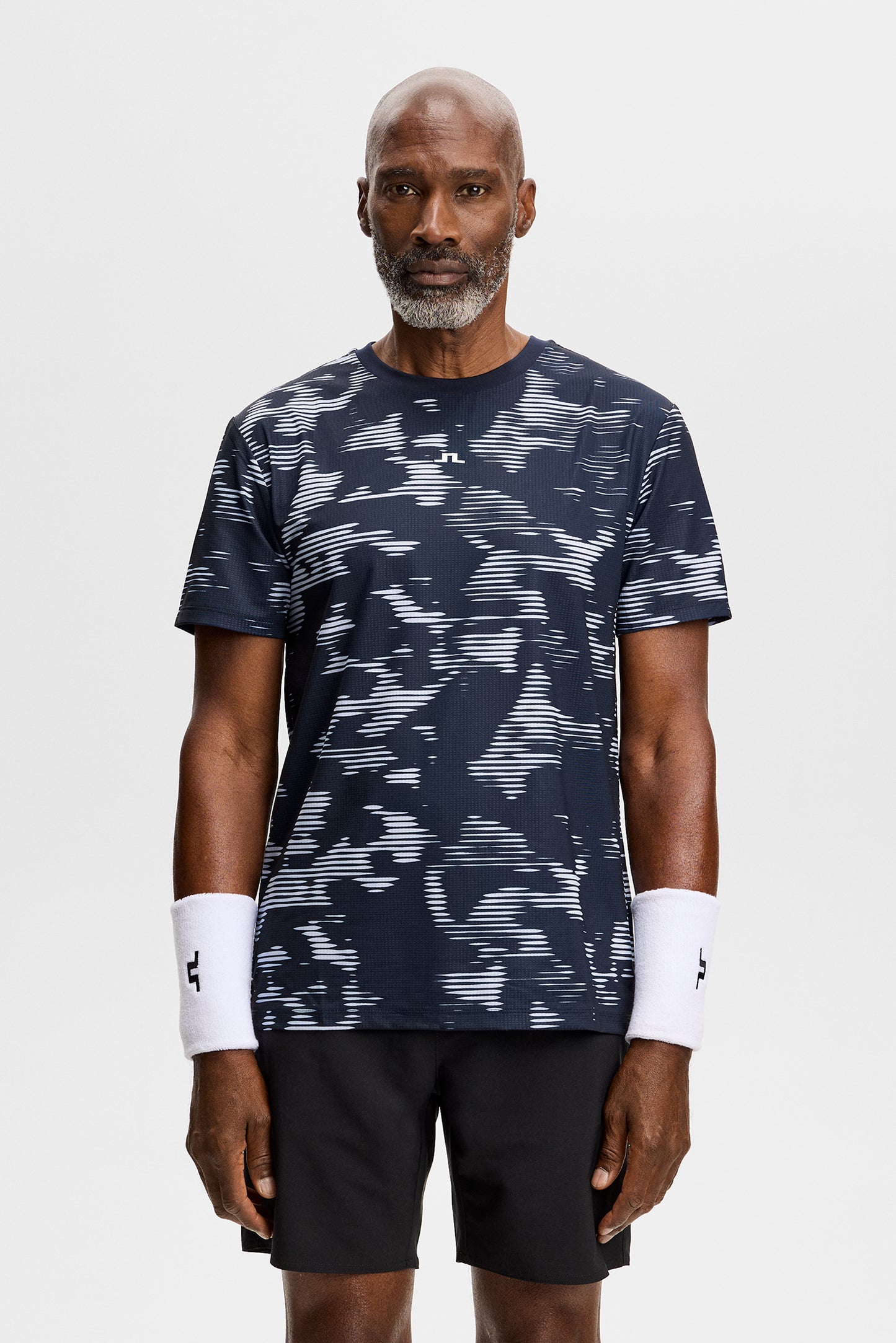 Vooraanzicht: Model draagt het Josip Printed T-shirt met all-over print en Bridge-logo op de borst.