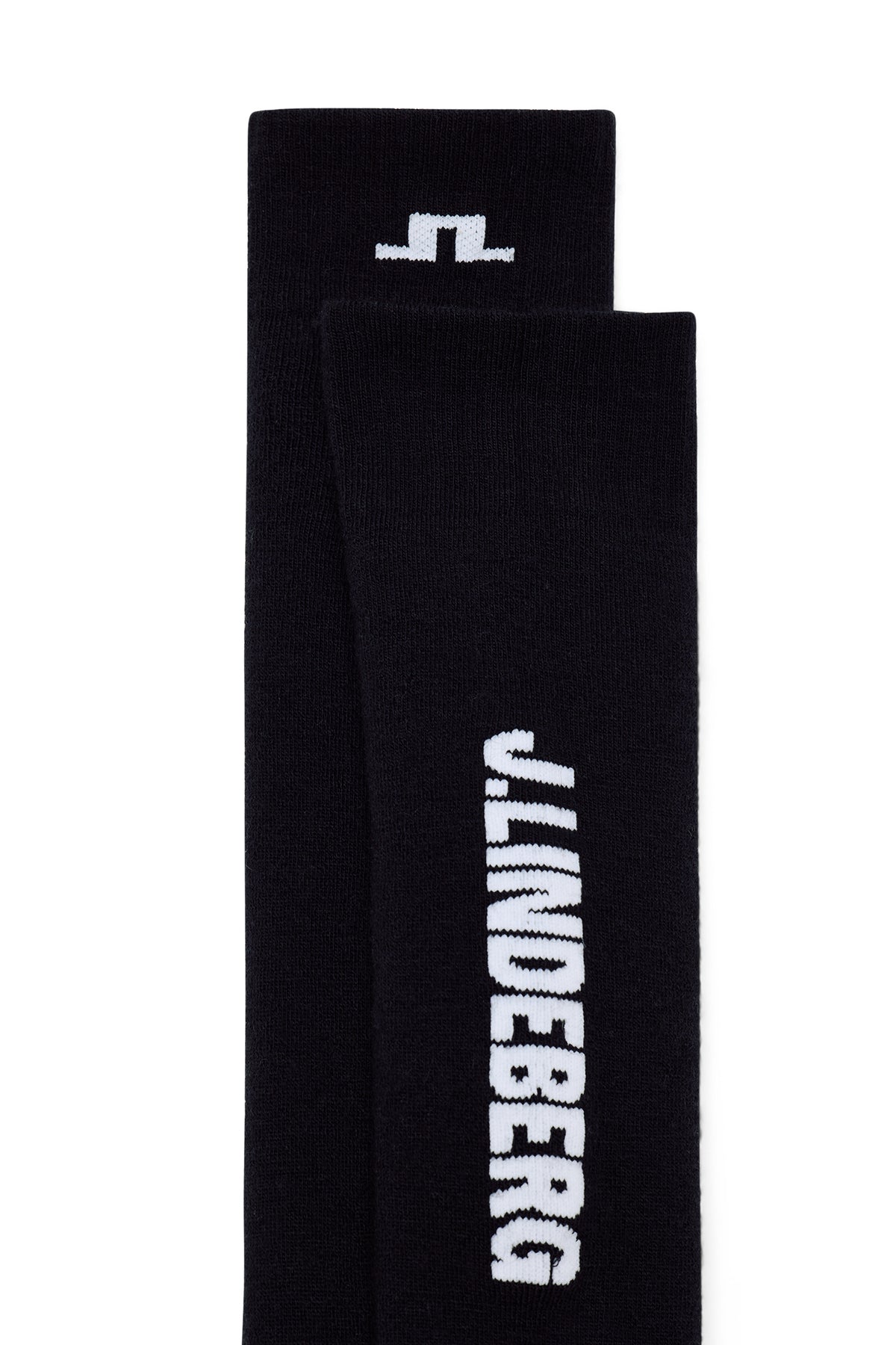 Close-up: Zwarte Reynold Ski sock met wit J.LINDEBERG-logo op de schacht en Bridge-logo op de geribde boord.