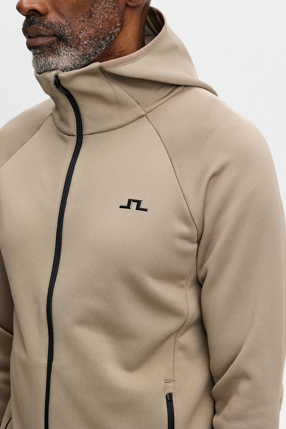 Gros plan : Pollock Polartec Hood en Brindle avec col montant, capuche et logo Bridge noir sur la poitrine.
