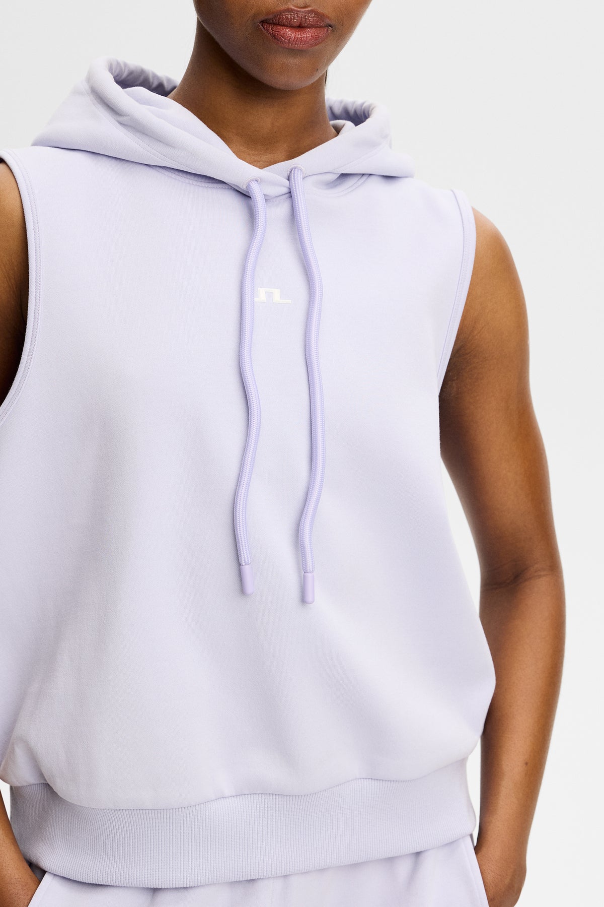 Nahaufnahme: Sarah Sleeveless Hood in Purple Heather mit Kapuze, Kordelzug und Bridge-Logo auf der Brust.