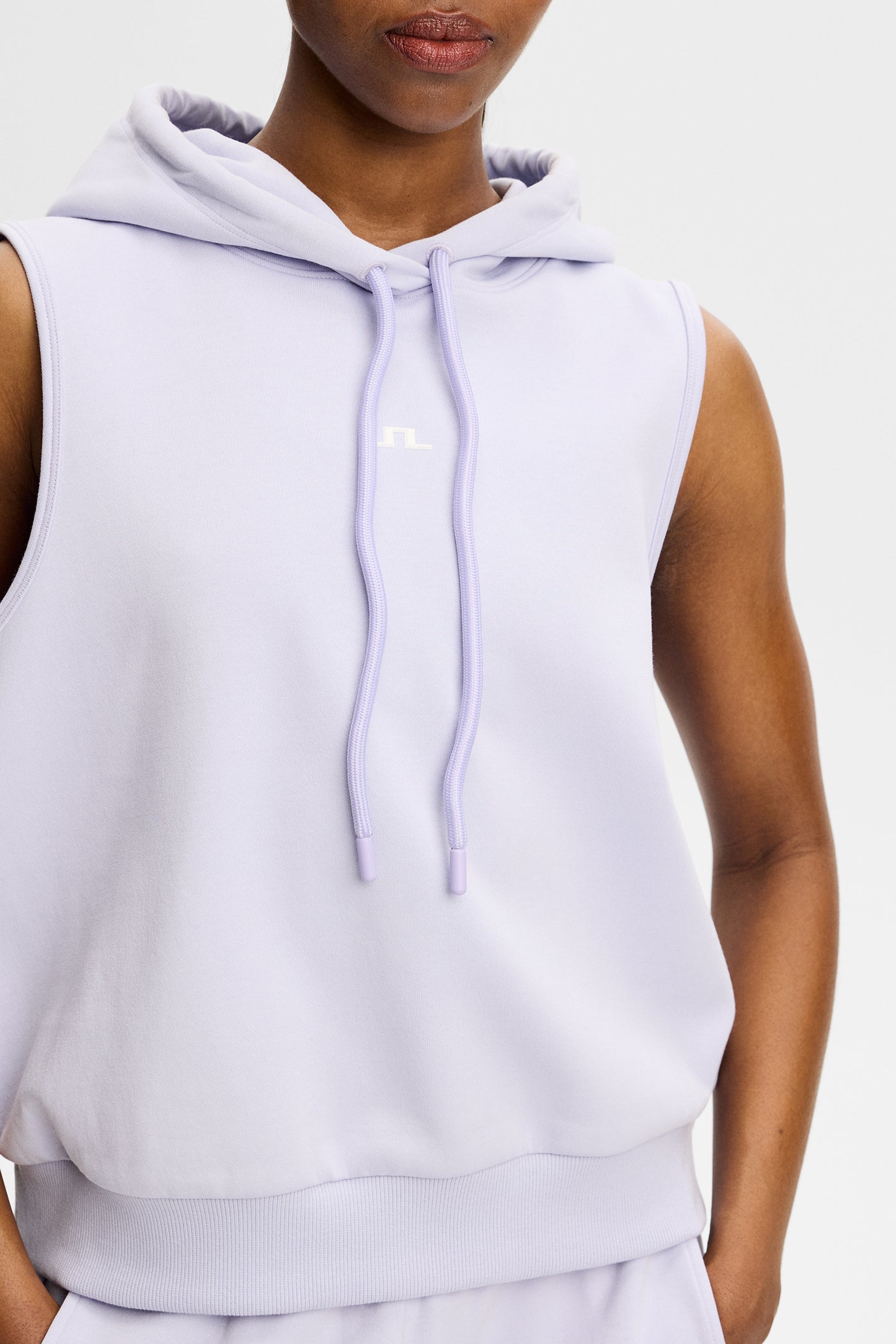 Nahaufnahme: Sarah Sleeveless Hood in Purple Heather mit Kapuze, Kordelzug und Bridge-Logo auf der Brust.