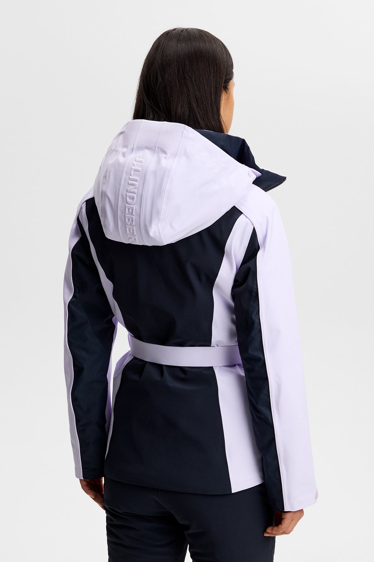 Rückansicht: Soleil Down Jacket in Purple Heather mit Taillengürtel und J.LINDEBERG-Logo auf der Kapuze.