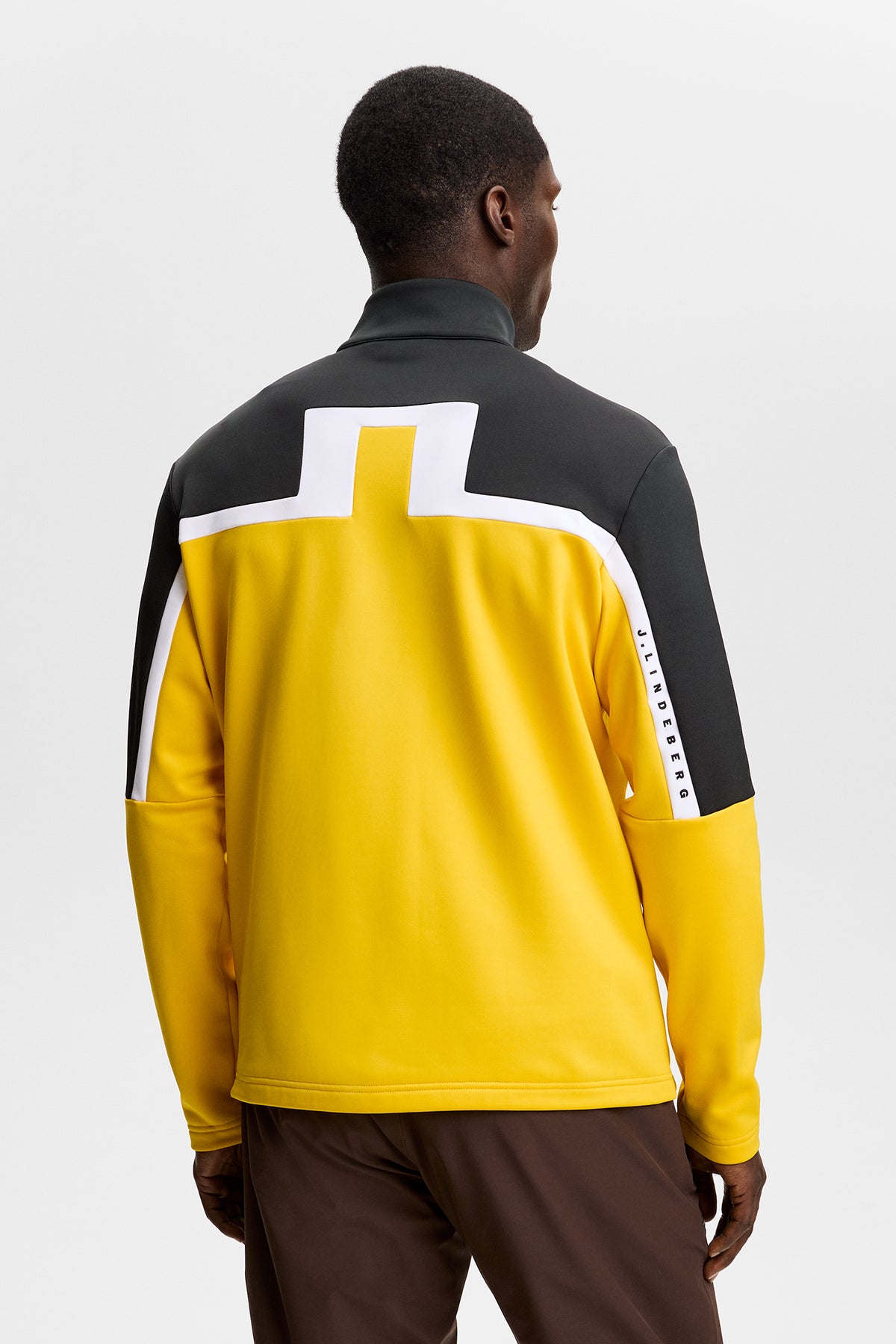 Vue de dos : Sharpe Full Zip Mid Layer jaune et noir avec grand logo Bridge blanc dans le dos.