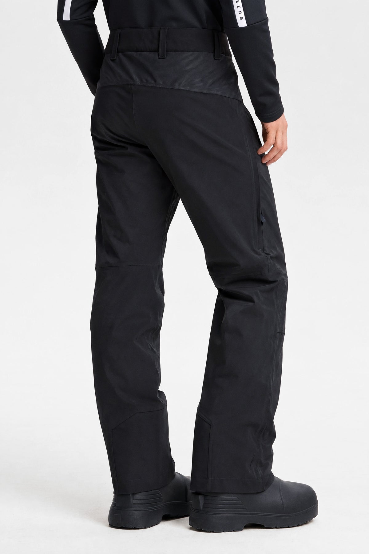 Back view of the Whitman Pant in black, featuring wide belt loops and side zipper details.