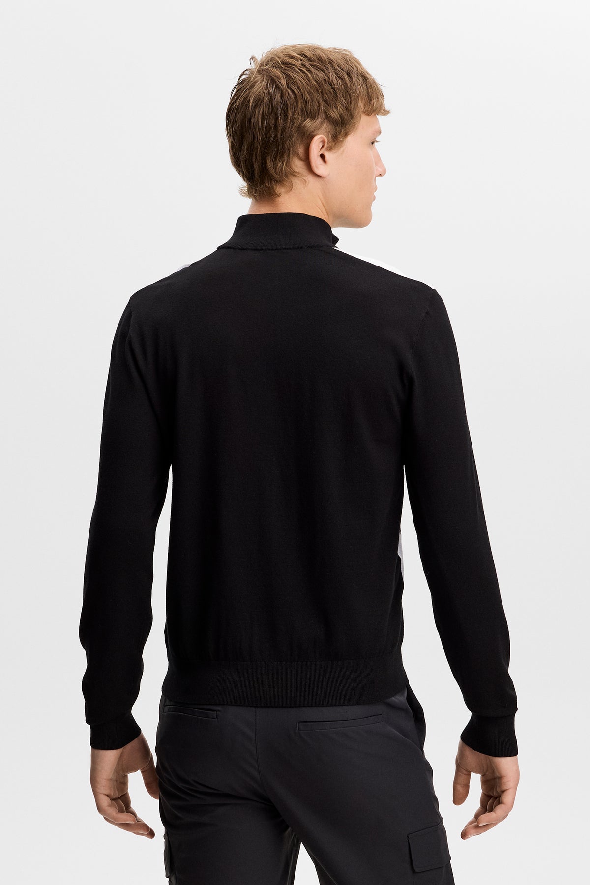 Rückansicht: Kendrick Knitted Zip Sweater in Schwarz am Model mit geripptem Saum und Bündchen.