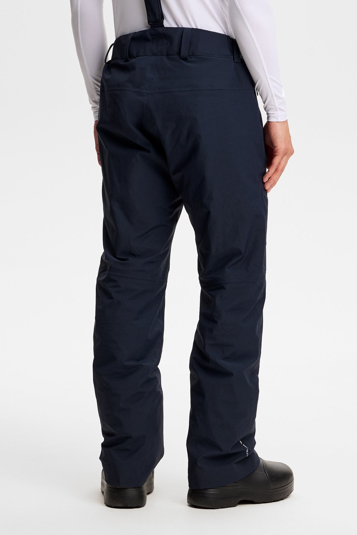 Rückansicht: Crue Suspender Pant in JL Navy mit Hosenträgern, Gürtelschlaufen und Bridge-Logo am Bund.