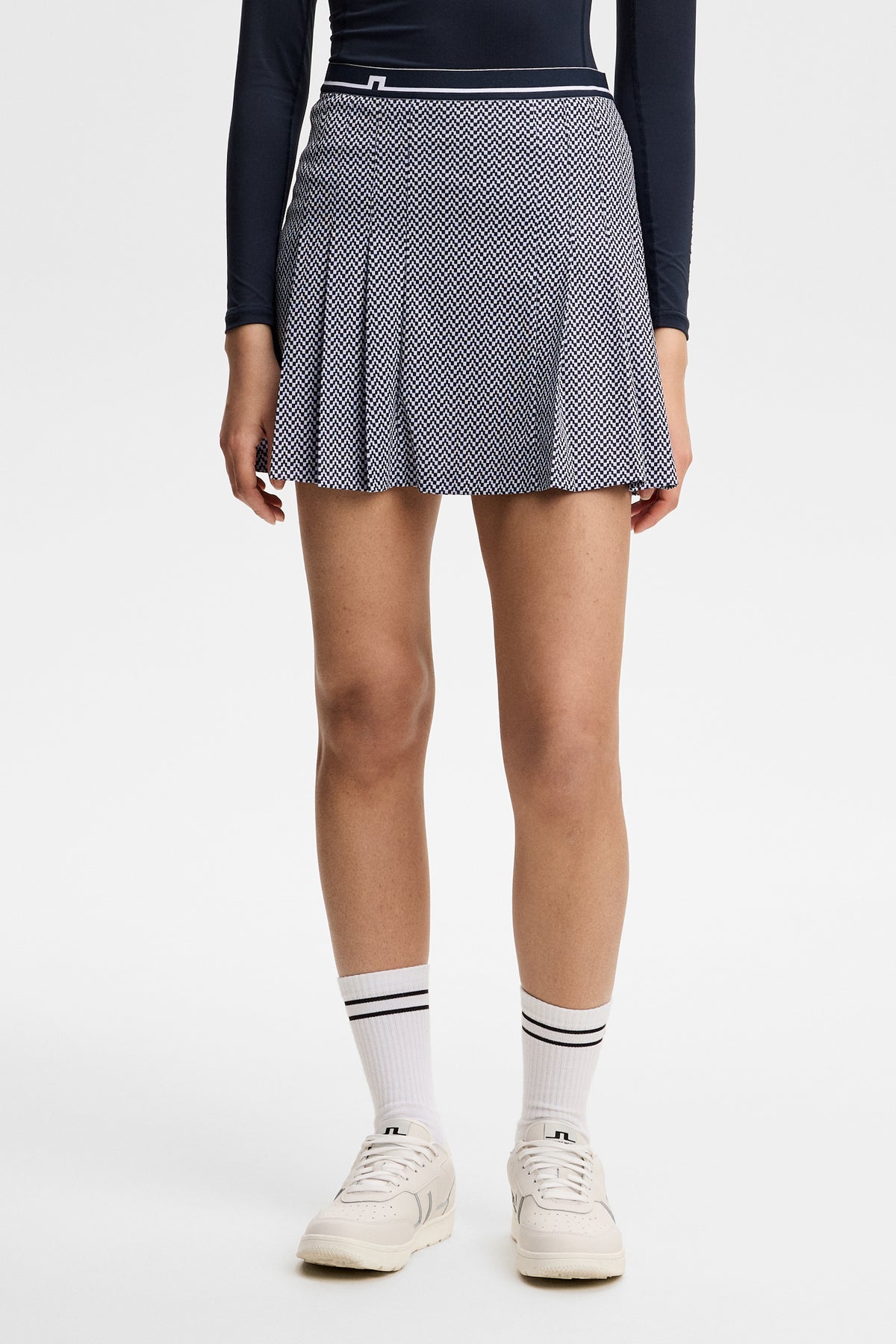 Vue de face : Harlow Print Skirt bleu marine à micro-motifs, plis cousus et logo Bridge à la taille.
