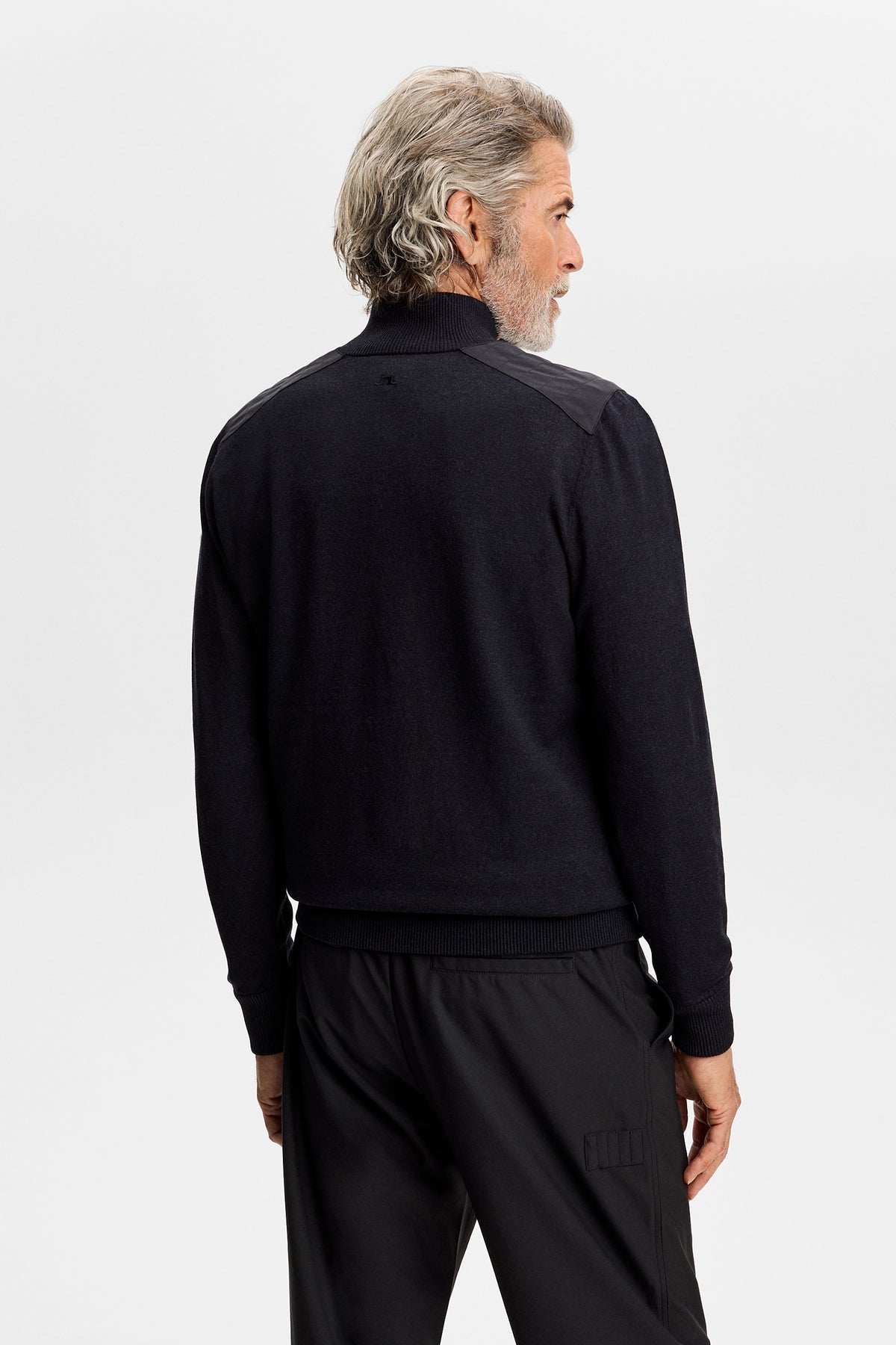 Bagfra: Jeffrey Windbreaker Sweater i sort med vævede skulderpaneler og et tonet Bridge-logo i nakken.