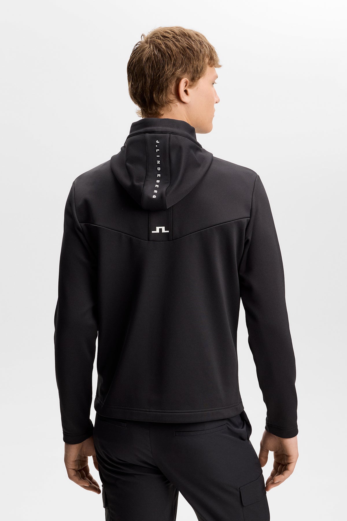 Maclean Zip Hood in black, back view showing J.Lindeberg text on the hood and a white Bridge logo.