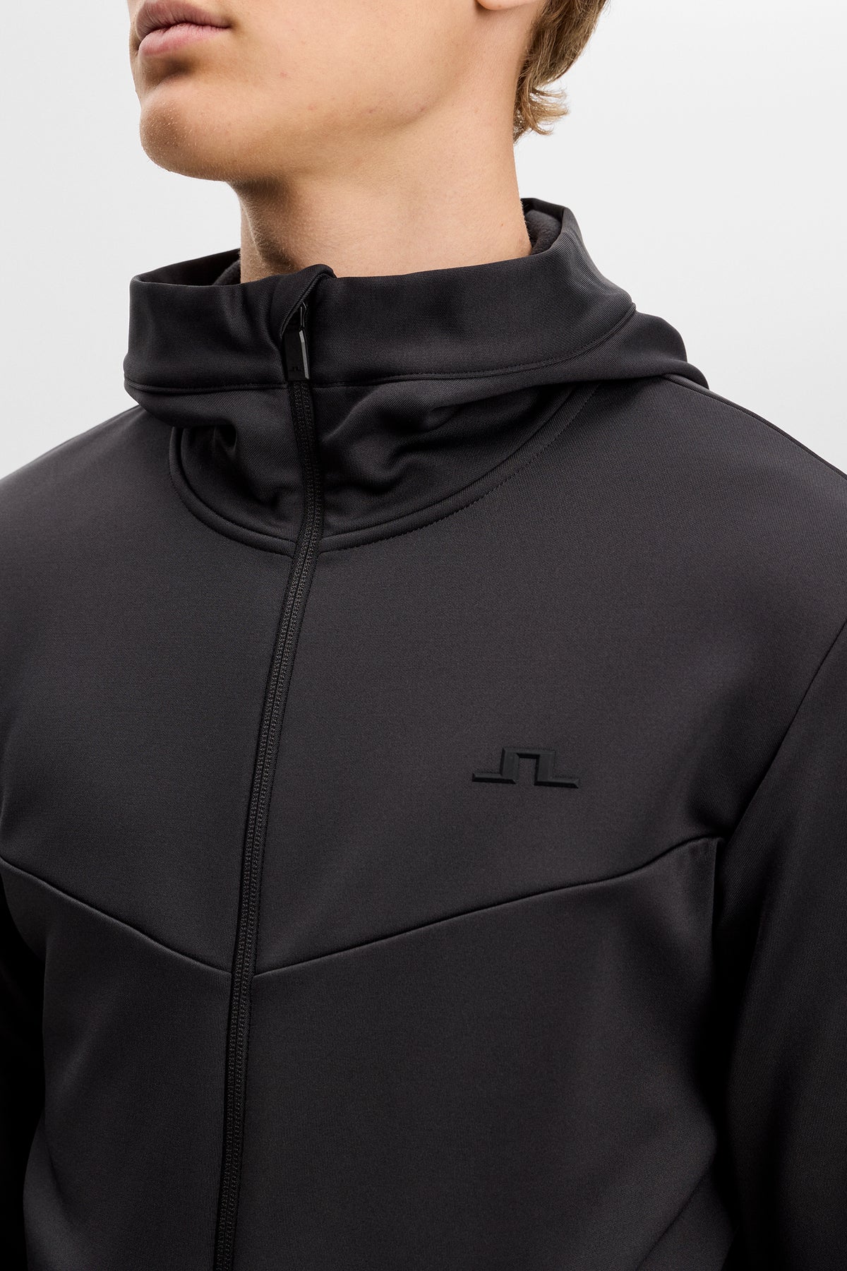 Close-up of the Maclean Zip Hood in black, featuring a front zipper, hood, and raised tonal Bridge logo on the chest.