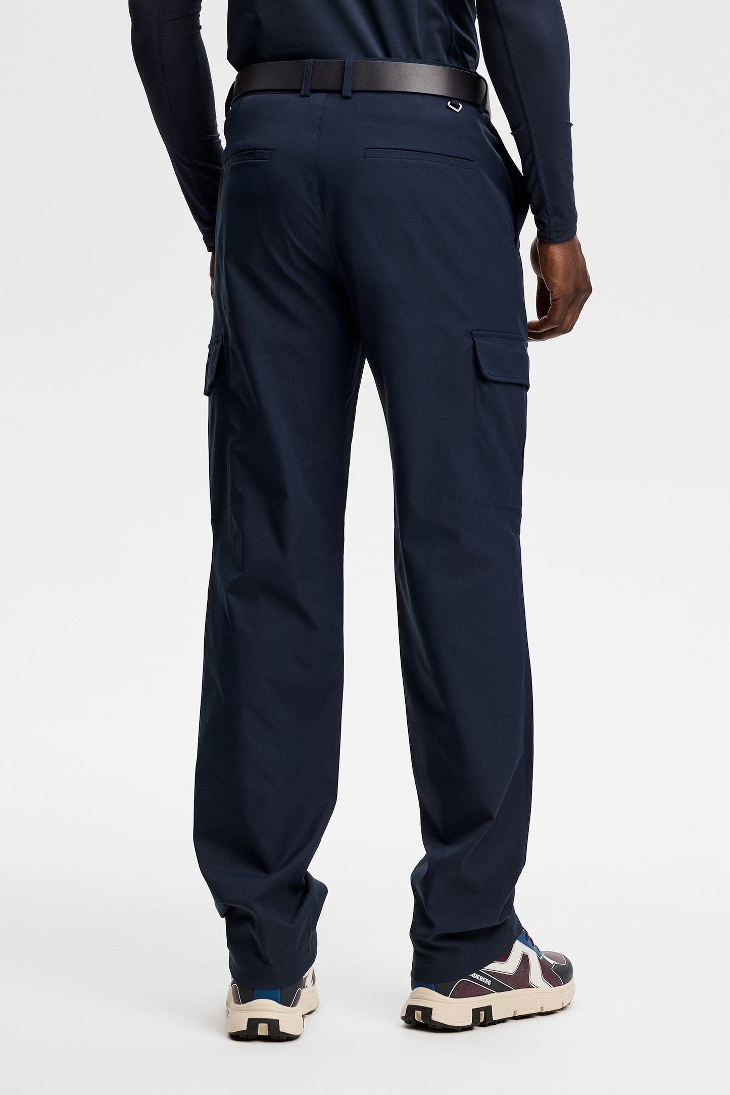 Model wearing the Logan Cargo pant in JL Navy, back view showing side cargo pockets in a studio setting.