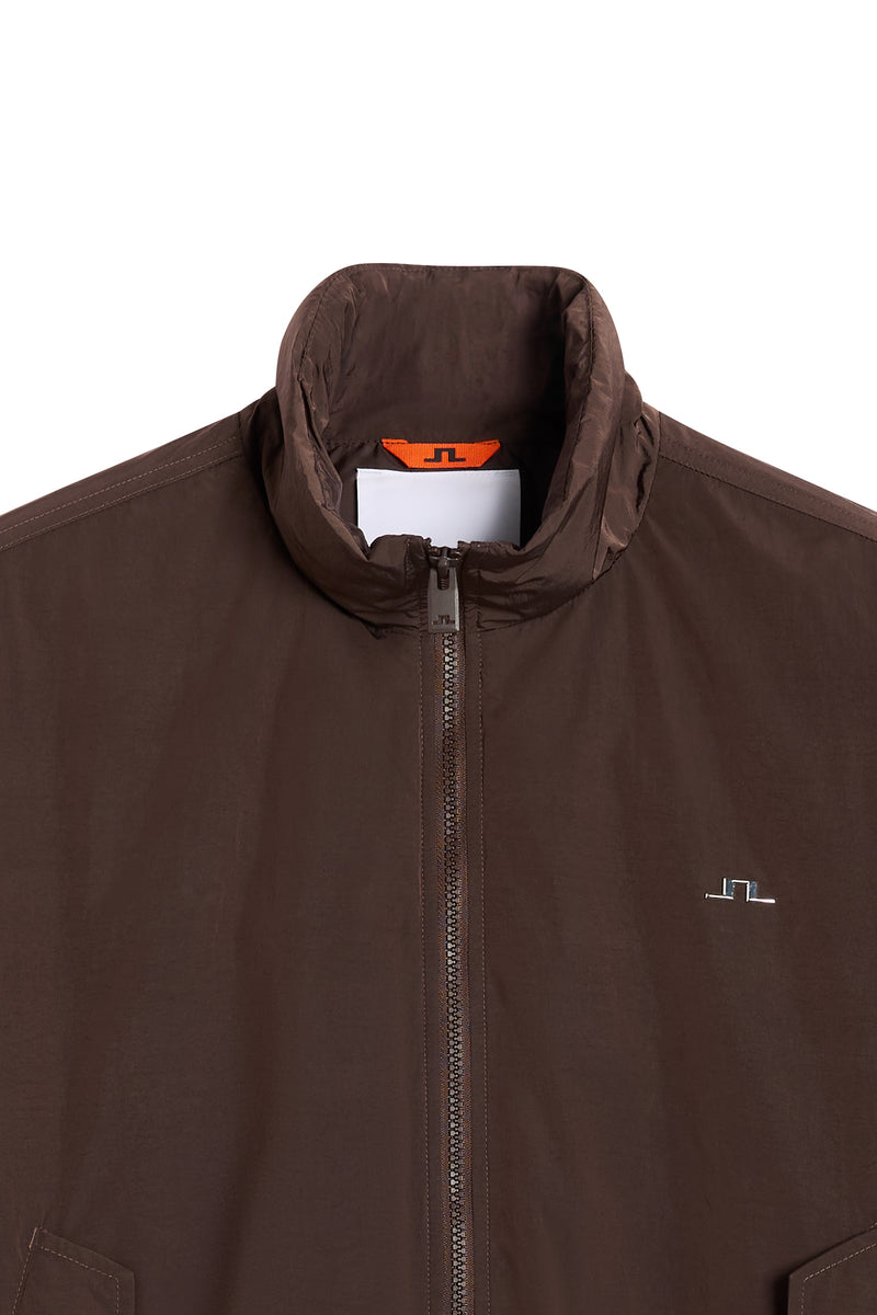 Close-up of the Eden Padded Jacket in Seal Brown, showing the high collar, front zipper, and Bridge logo.