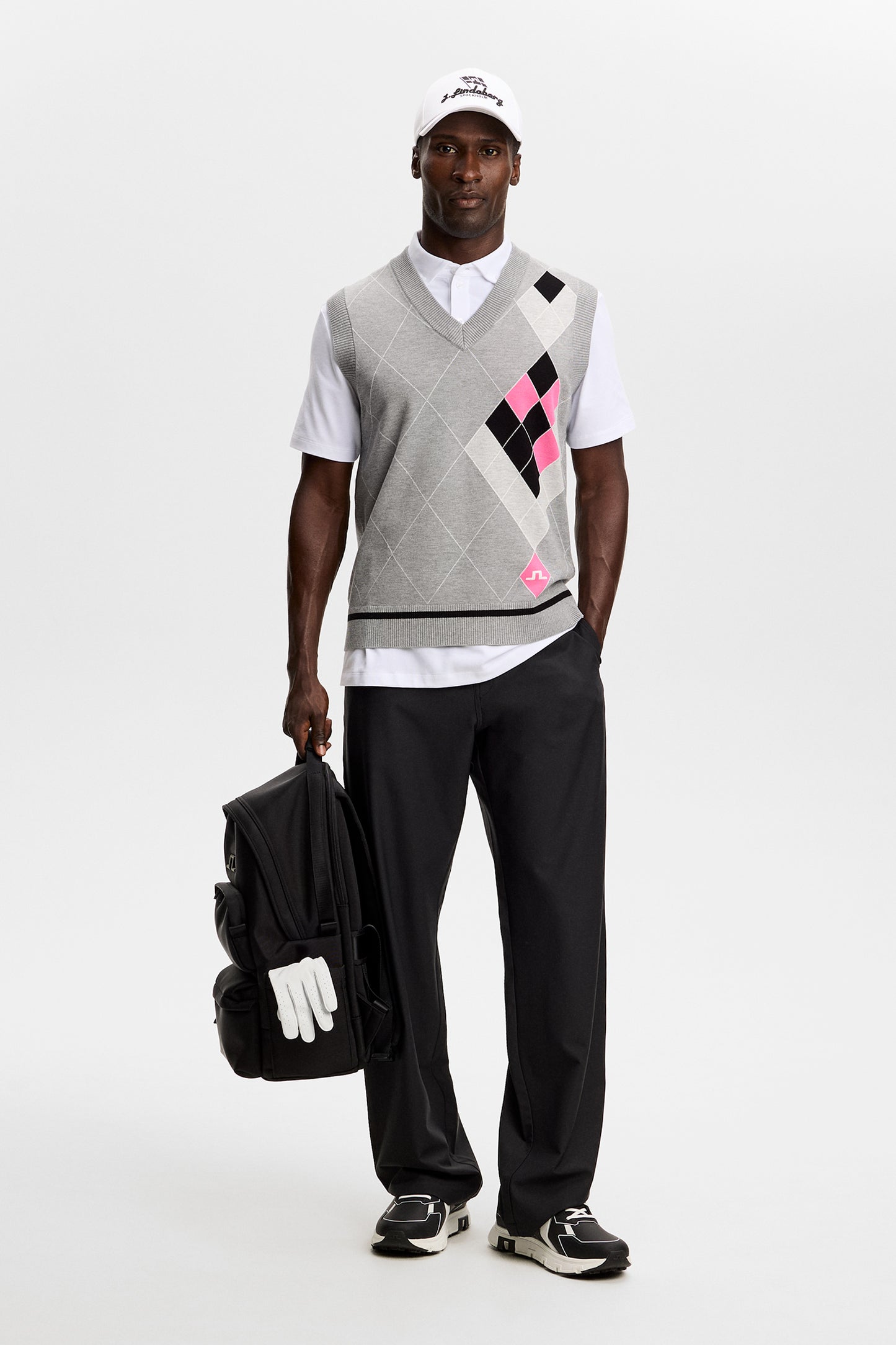 Vue de face : Anton Argyle Knit Vest gris à motif losanges noir et rose, col en V et logo Bridge.