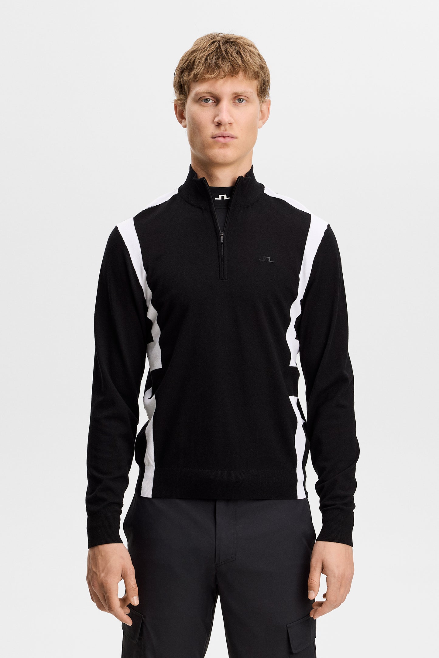 Vorderansicht: Kendrick Knitted Zip Sweater in Schwarz am Model, mit halbem Reißverschluss und weißen Seiteneinsätzen.
