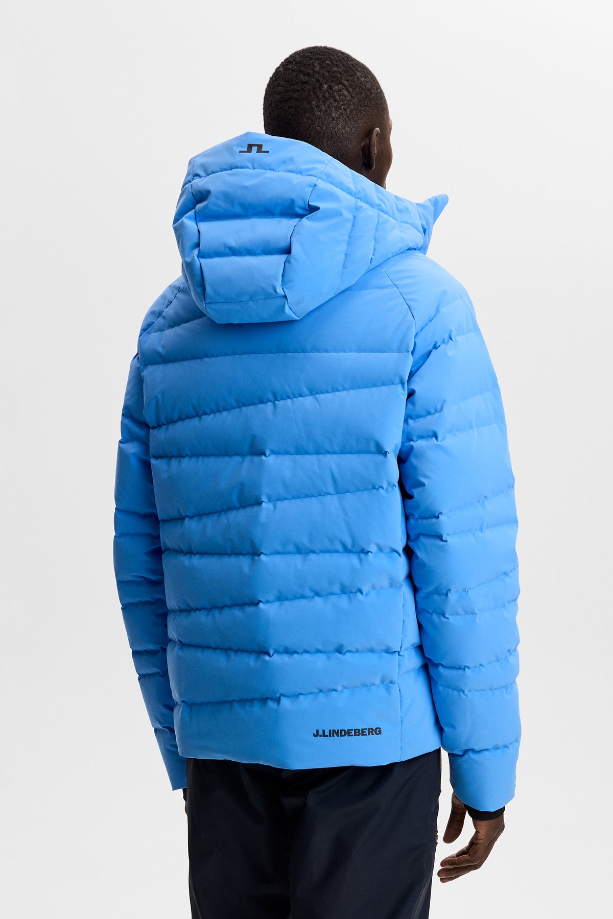 Back view: Thornton Down Jacket in Sonic Blue with quilted panels, hood with Bridge logo, and back logo.