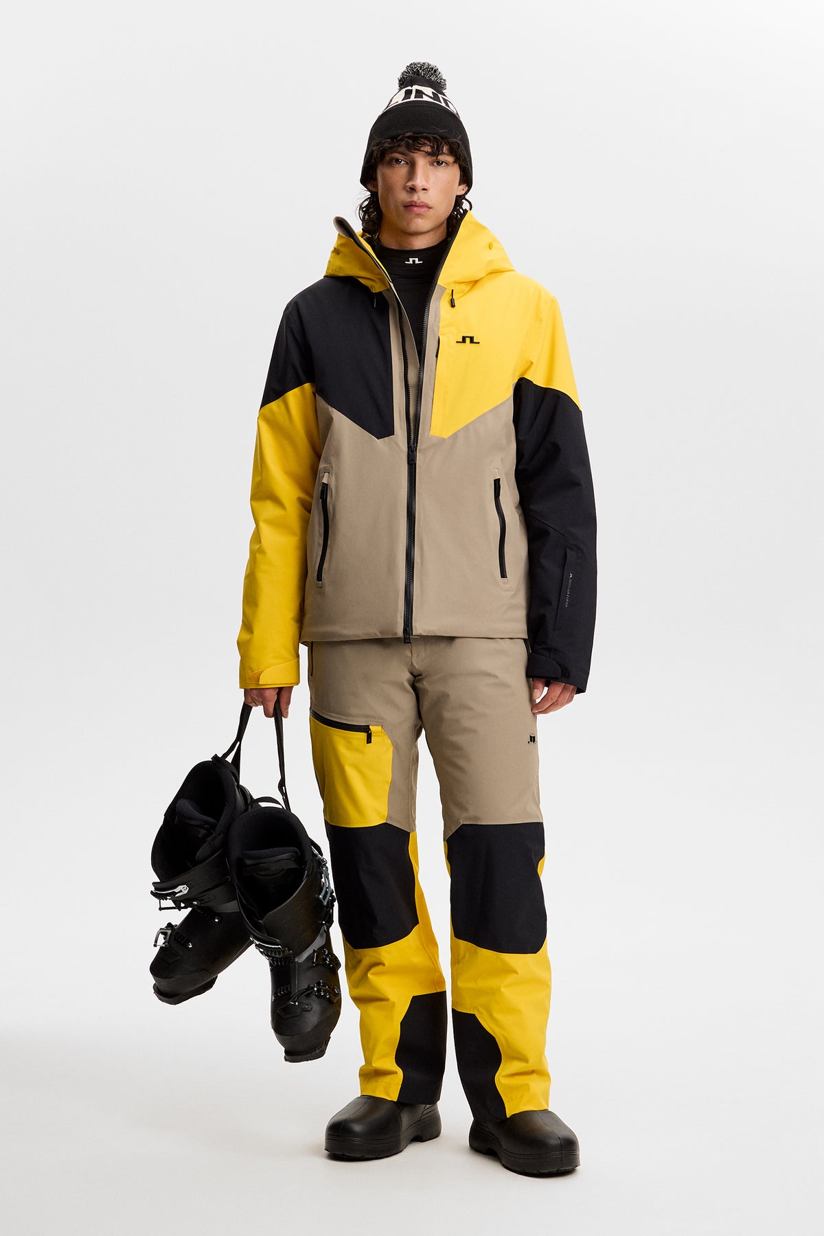 Forfra: Caldwell Jacket i Bumblebee med farveblokering, Bridge-logo på brystet og matchende skibukser.