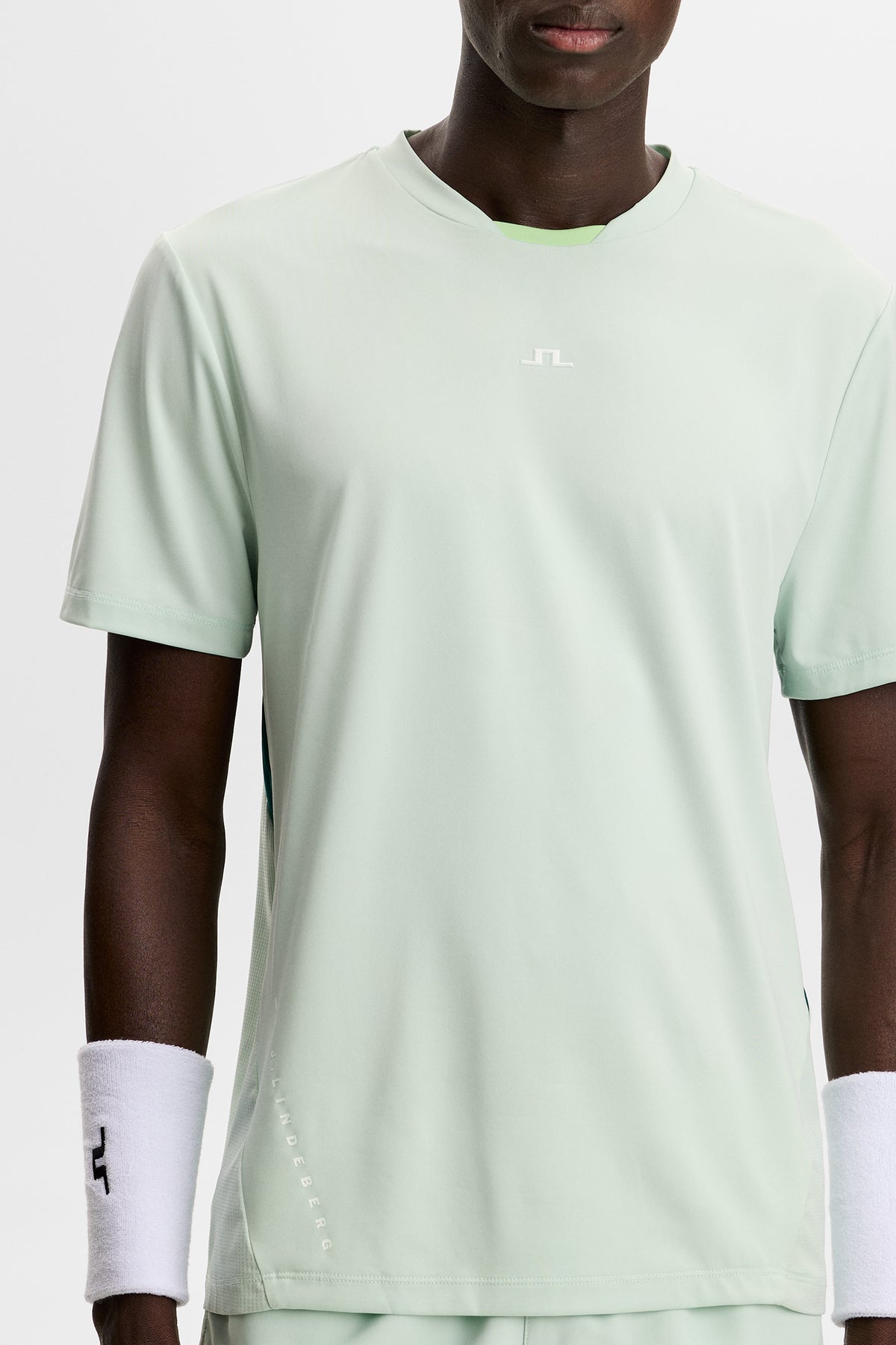 Model wearing the light green Dennis T-shirt featuring a crew neck and white Bridge logo on the chest in a studio.