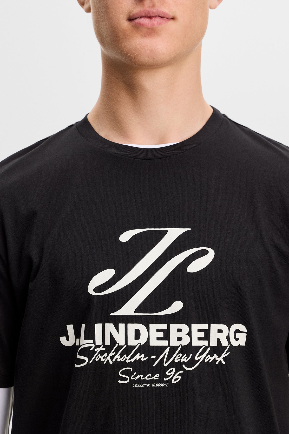 Close-up of the black Alpha Graphic T-shirt showing the ribbed crew neck and J.Lindeberg chest graphic.