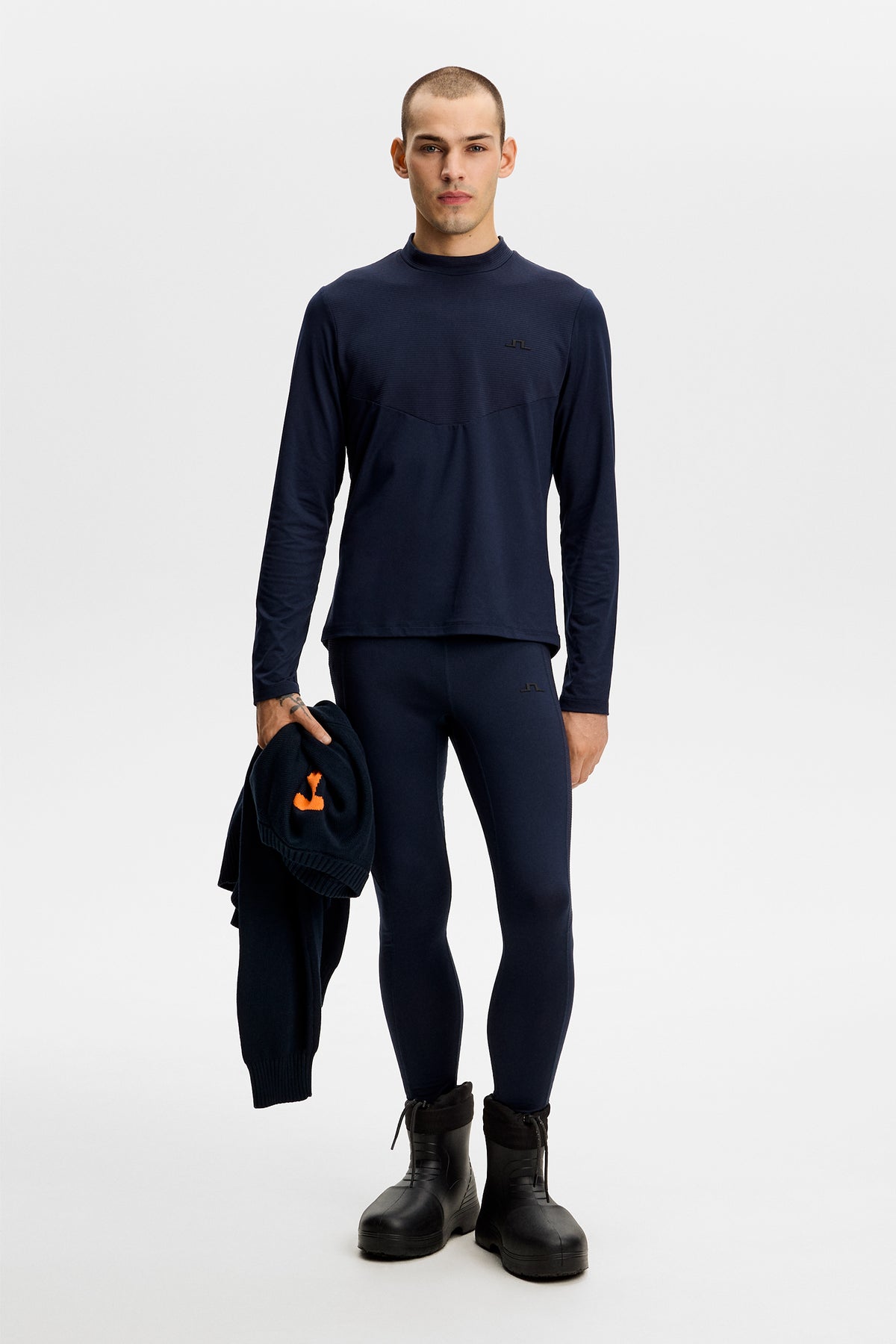 Model wearing the Zenit Baselayer Pant in JL Navy with matching top in a studio setting.
