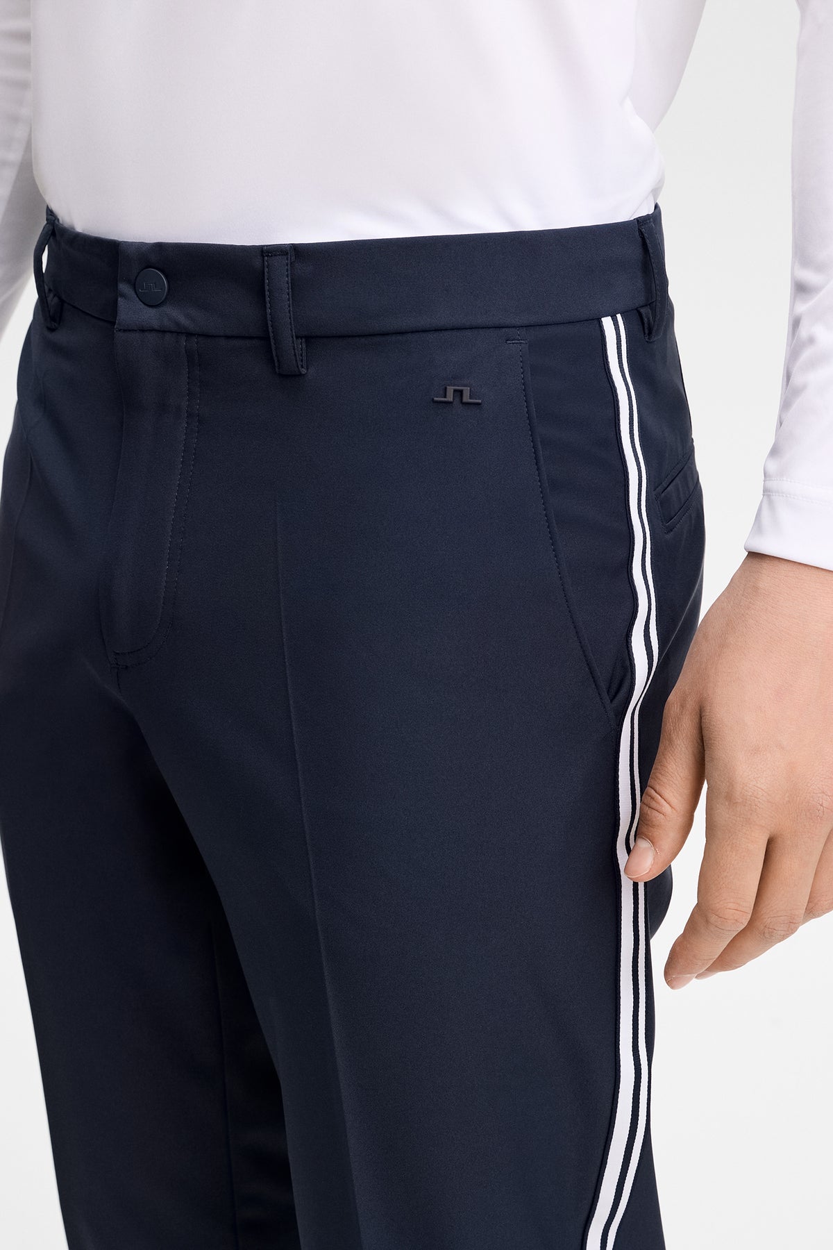 Close-up view of the Mitch Stripe tech pants in JL Navy, highlighting the side stripe tape and Bridge logo rivet.