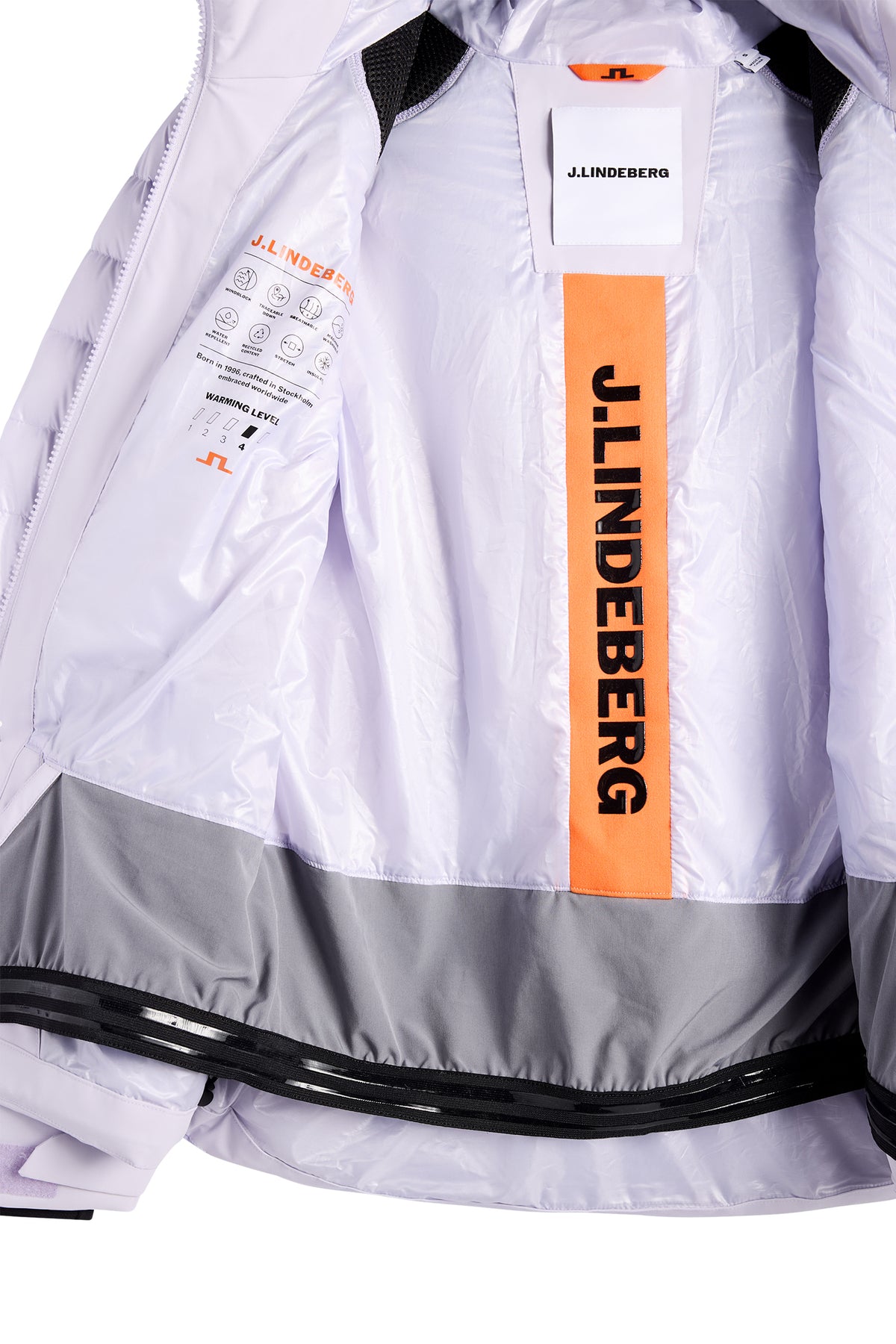 Nærbillede: Indersiden af Maelle Down Jacket med lyst for, orange J.Lindeberg-stribe og integreret snefang.